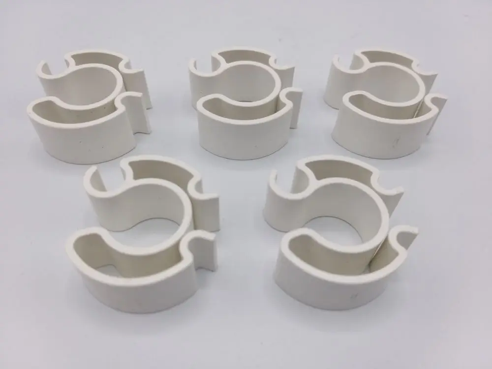 Sechs weiße Klemmteile in leichter plastischer Form, verwendet zur Befestigung oder Lagerung, bereit für Anwendungen, eventuell von Remeha.
